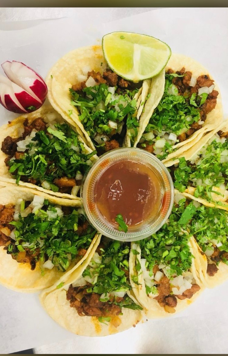 Platter of street tacos with onion, cilantro, radish and salsa at Jake's Meats