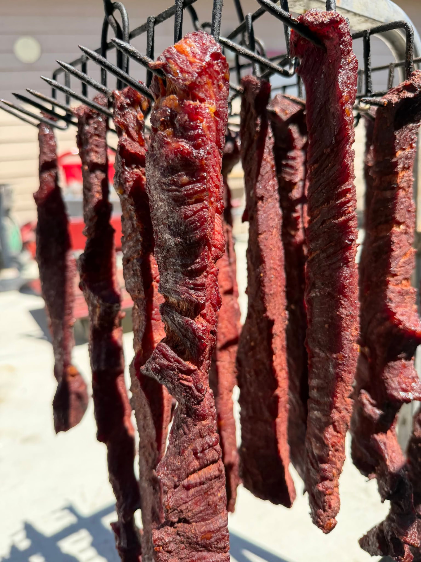 House-made beef jerky hanging on the drying rack at Jake's Meats