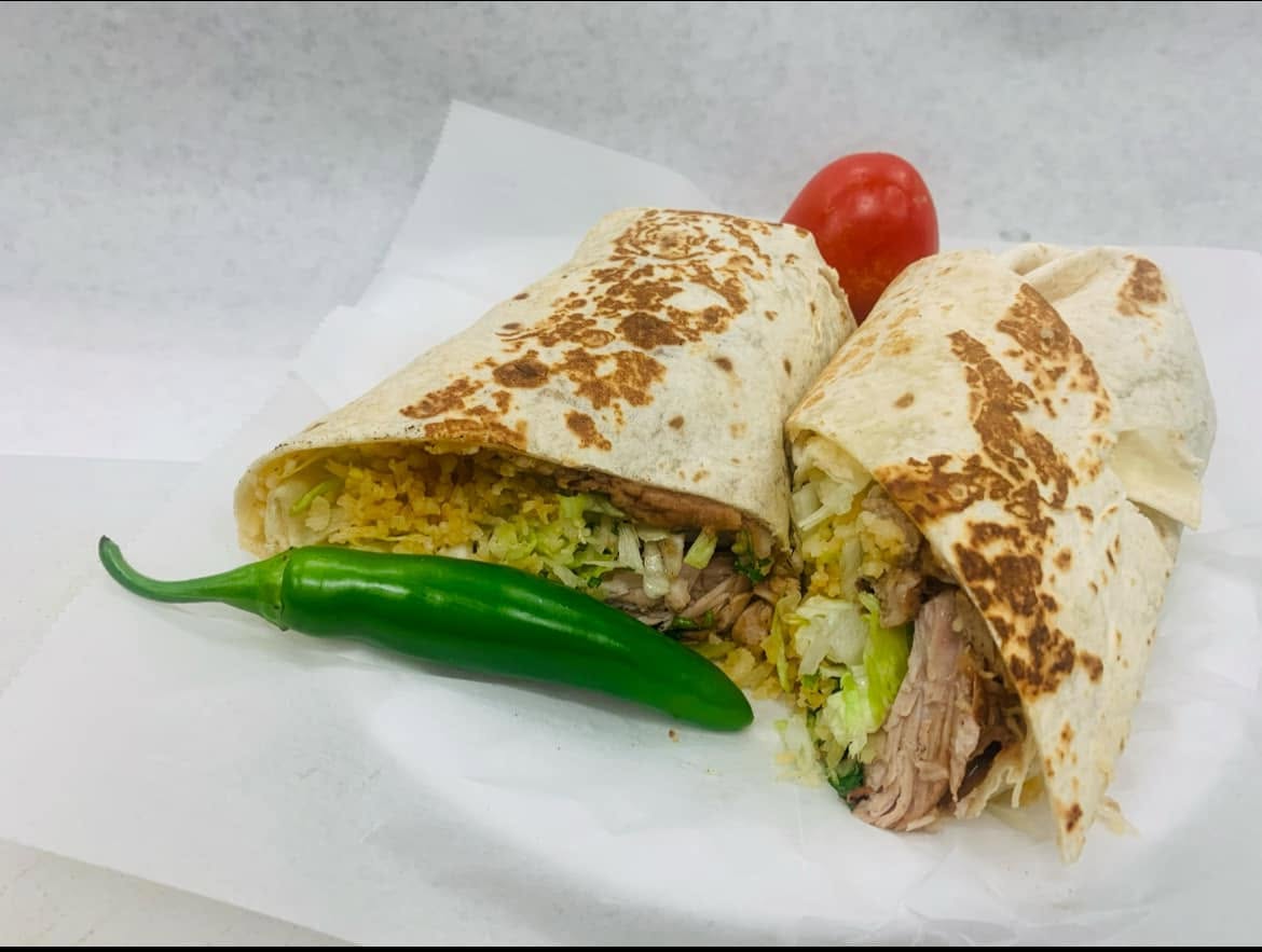 Burrito cut in half showing carne asada, rice and beans