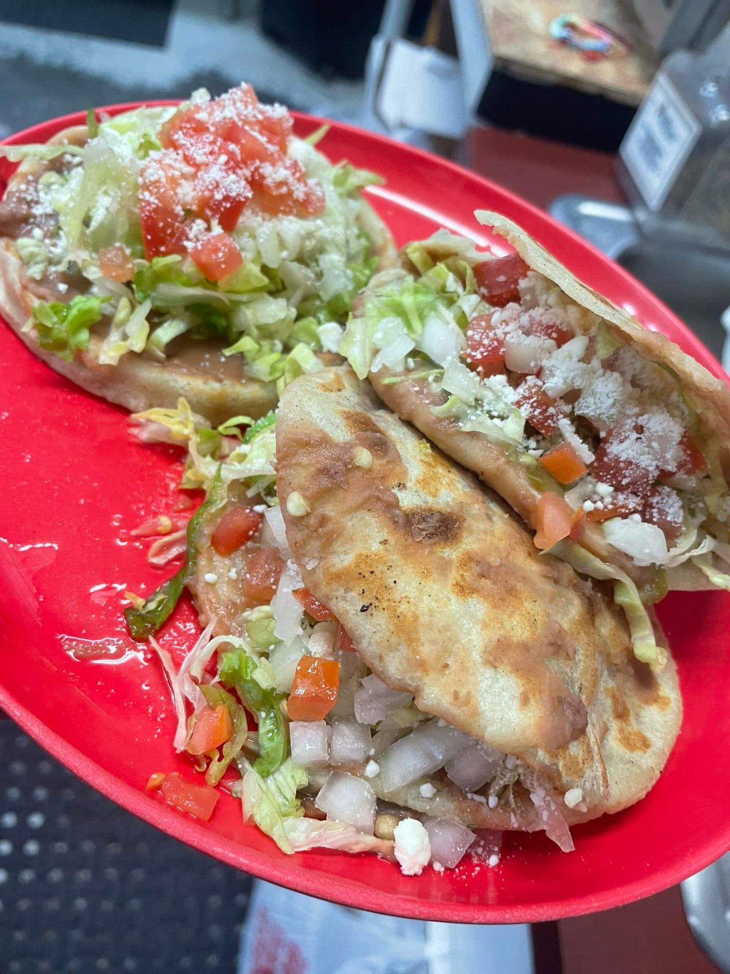 Gorditas filled with beans and meat, topped with lettuce, tomato and queso fresco